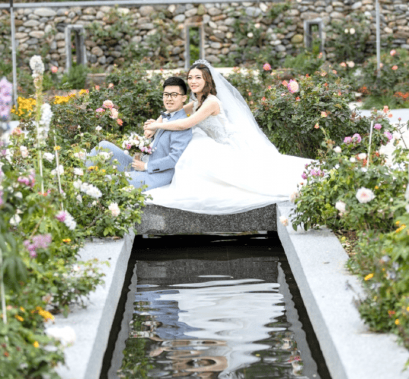 秘密花園水景區各色玫瑰花與新人的身影共同映照在水面上，顯得格外夢幻。