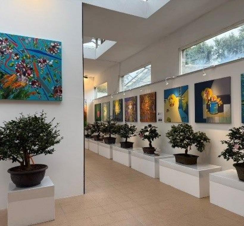 室內展場展示茶花盆景與藝術畫作，融合園藝與藝術之美